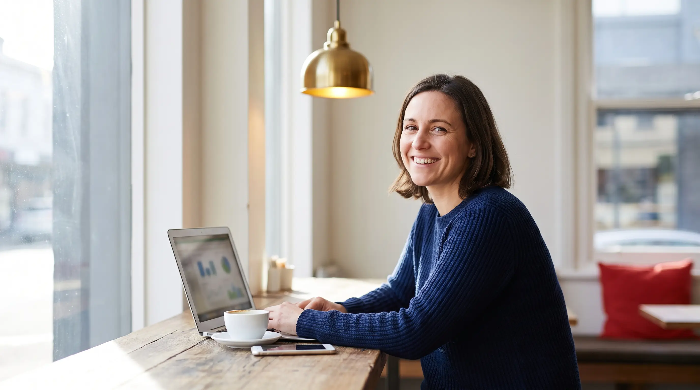 Melbourne small-business owner reviewing her marketing results on a laptop in a cafe
