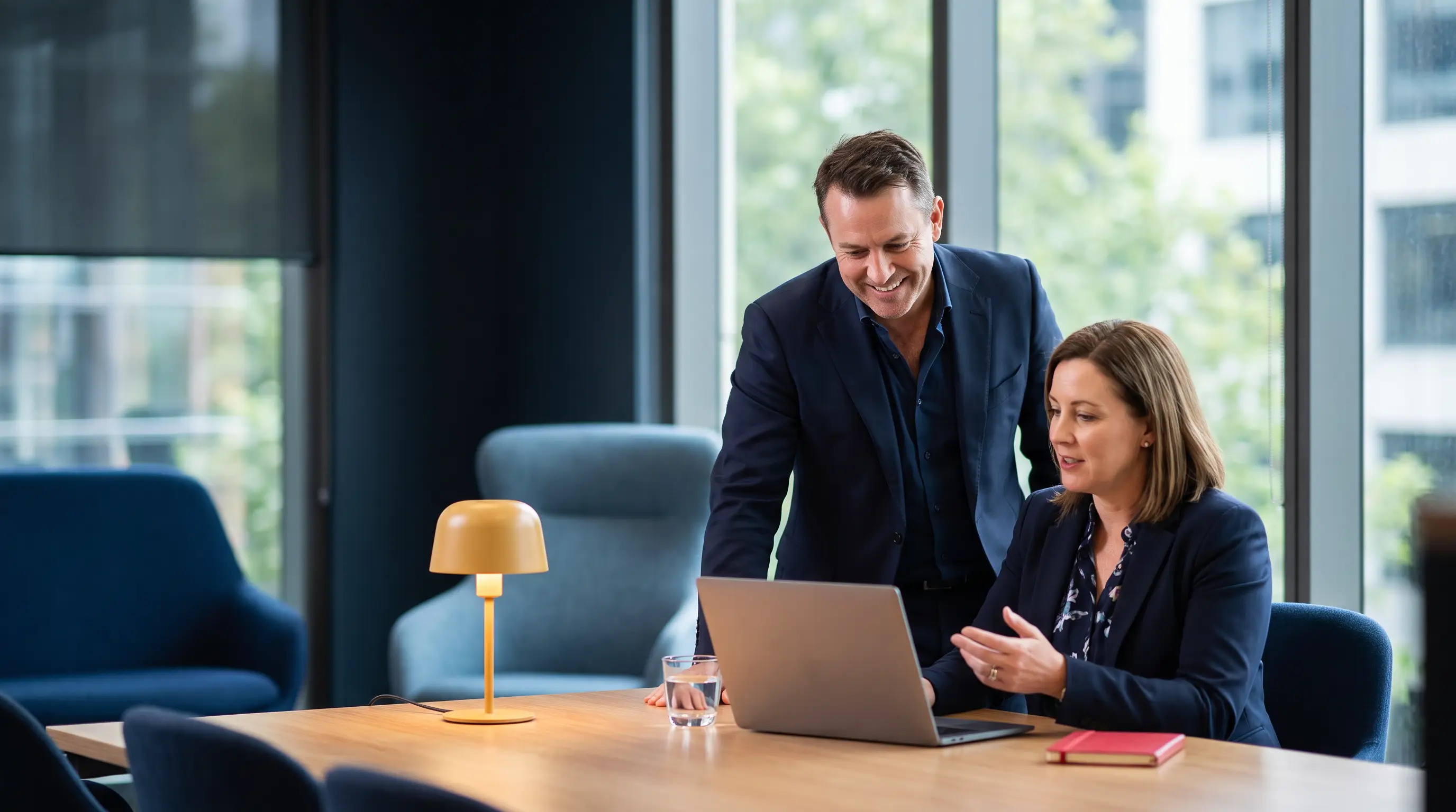 Business owner and senior marketing consultant discussing a plan together in a modern Melbourne office