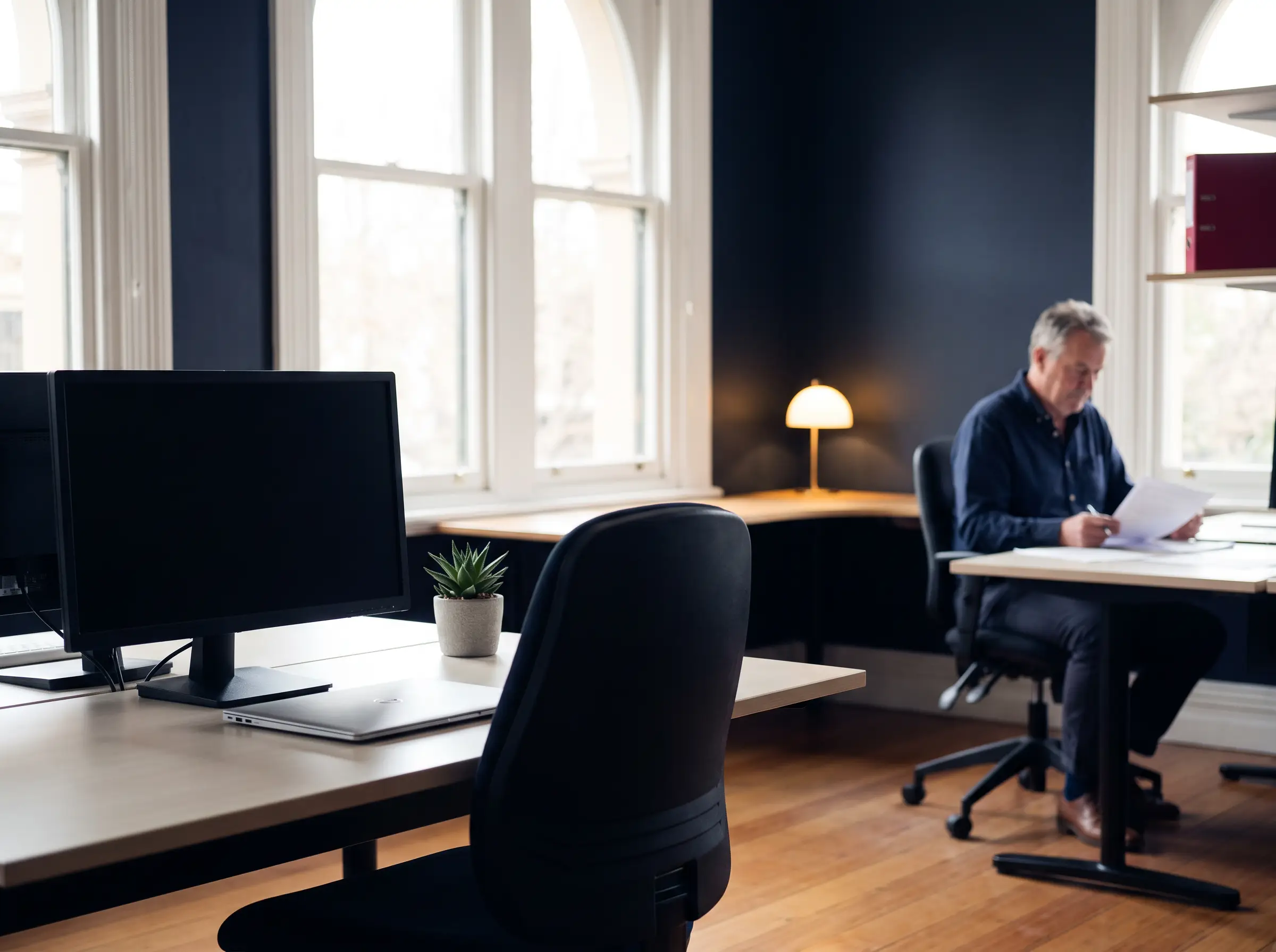 A tidy but empty marketing desk with a dark monitor in an established Australian business office